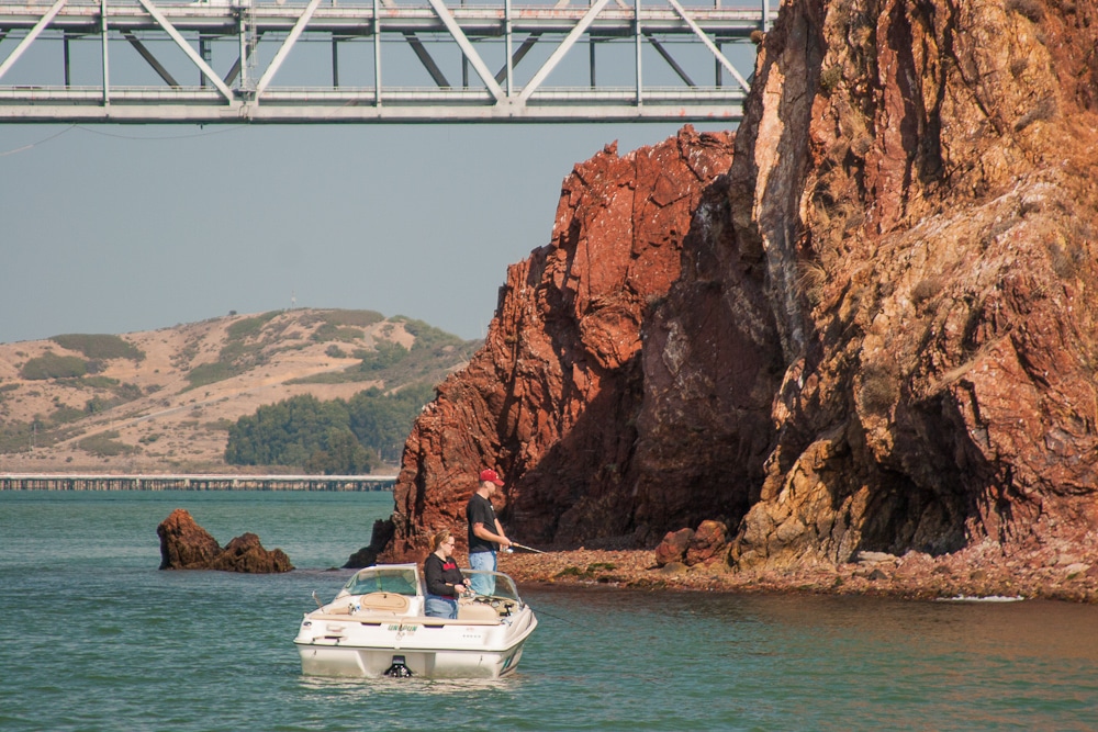 Two People Fishing Beside Red Rock Island